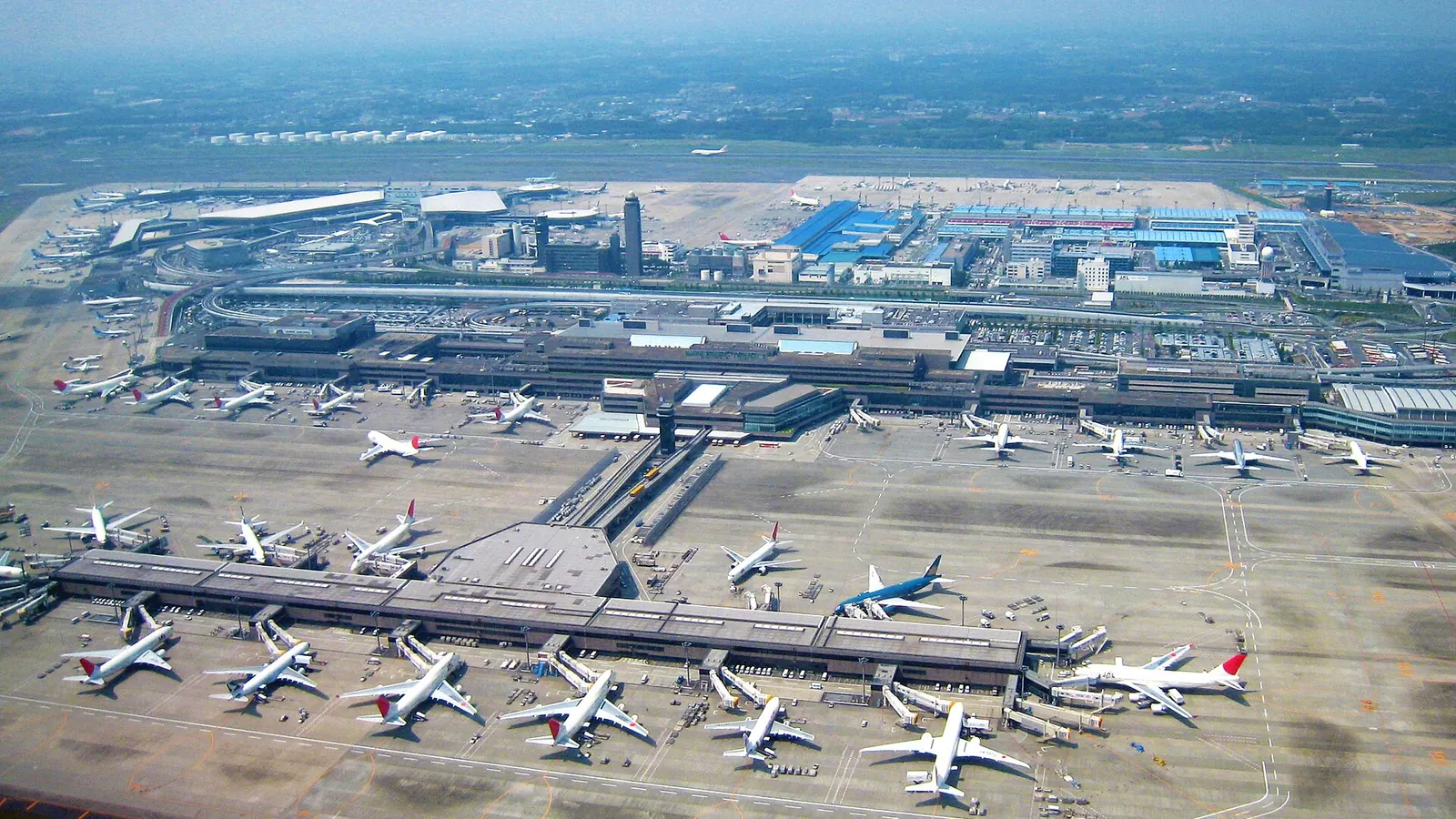 上空から見た成田空港。分かれて建つターミナルと駐機する旅客機