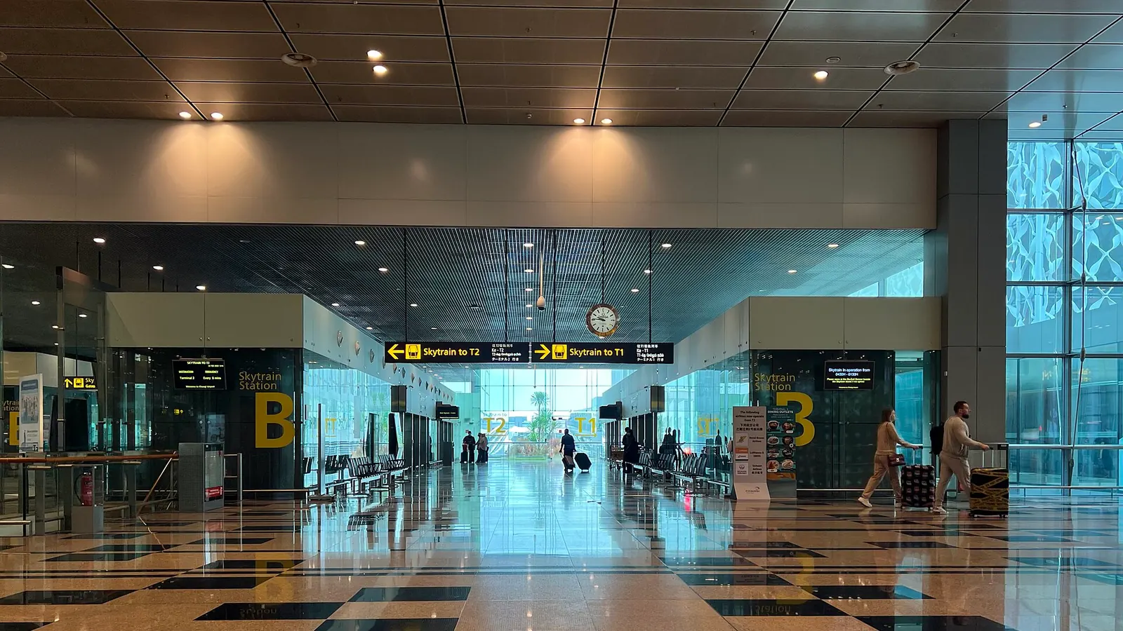 乗り継ぎの案内表示が並ぶ国際空港のターミナル内